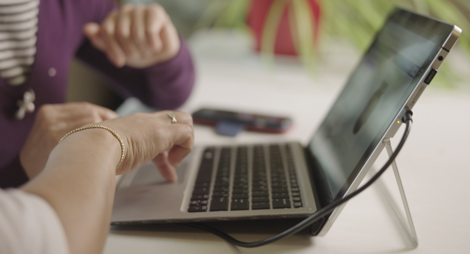 A woman's hands on a laptop touchpad.